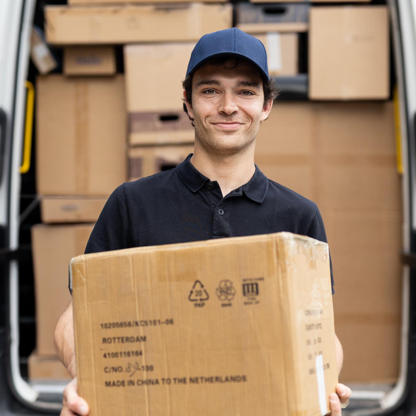 Koerier met pakket voor zijn camionette